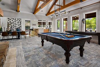 a large living room with a pool table and a bar